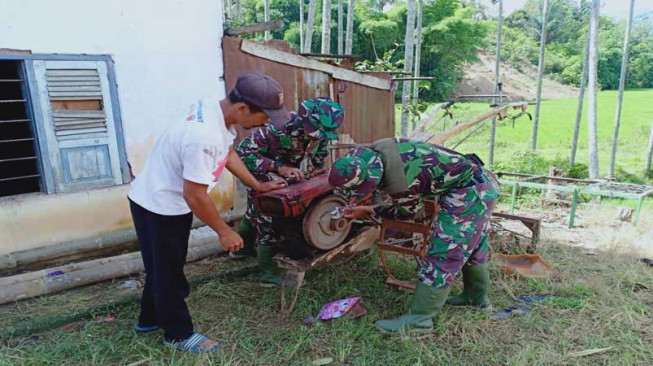 Anggota TNI Bantu Warga Perbaiki Mesin Bajak Sawah
