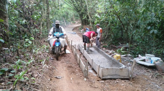 Warga dan Anggota Satgas TMMD Melangsir Material