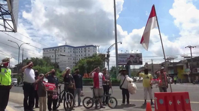 Warga Hormat Bendera di Lampu Merah