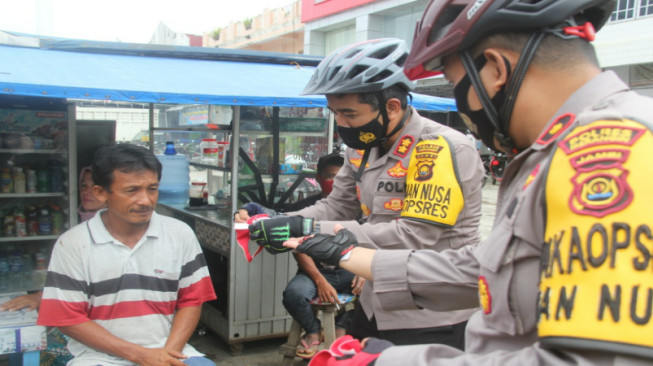 Sambil Patroli Bersepeda, Kapolres Merangin Bagikan Masker ke Warga