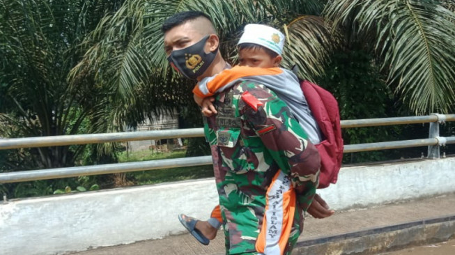 Kereeen... Tentara Ini Gendong Anak SD Pulang ke Rumahnya