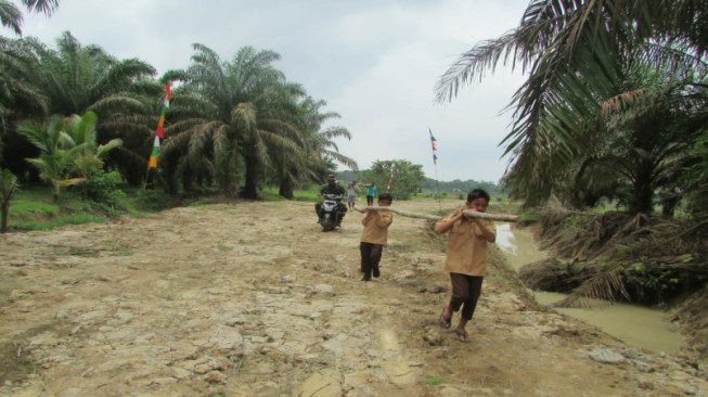 Masih Berseragam Sekolah, Anak-Anak Desa Sungaiterap Ikut Gotong Royong Pasang Galar