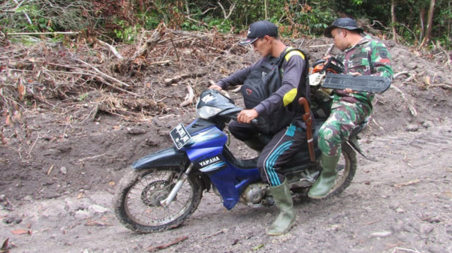 Warga dan Satgas Berboncengan Bawa Mesin Chainsaw