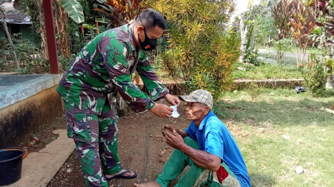 Sebelum Merangkai Besi MCK, Anggota TNI Pasangkan Masker ke Warga