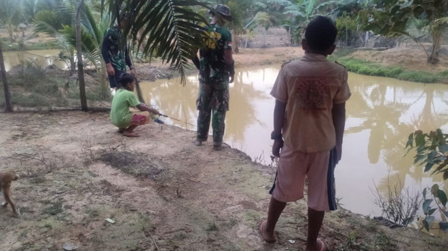Manfaatkan Waktu Senggang, Satgas dan Anak-anak Mancing Ikan