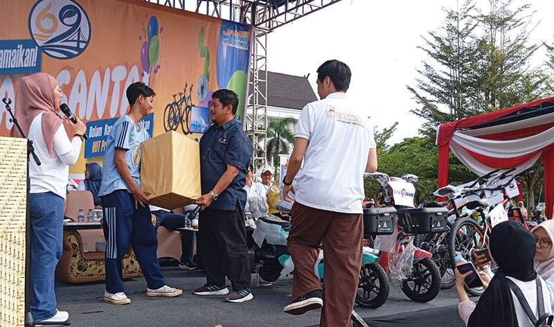 Government and Relation Superintendent PetroChina International Jabung Ltd, Saipul, menyerahkan hadiah doorprize kepada peserta Jalan Santai | foto: dod